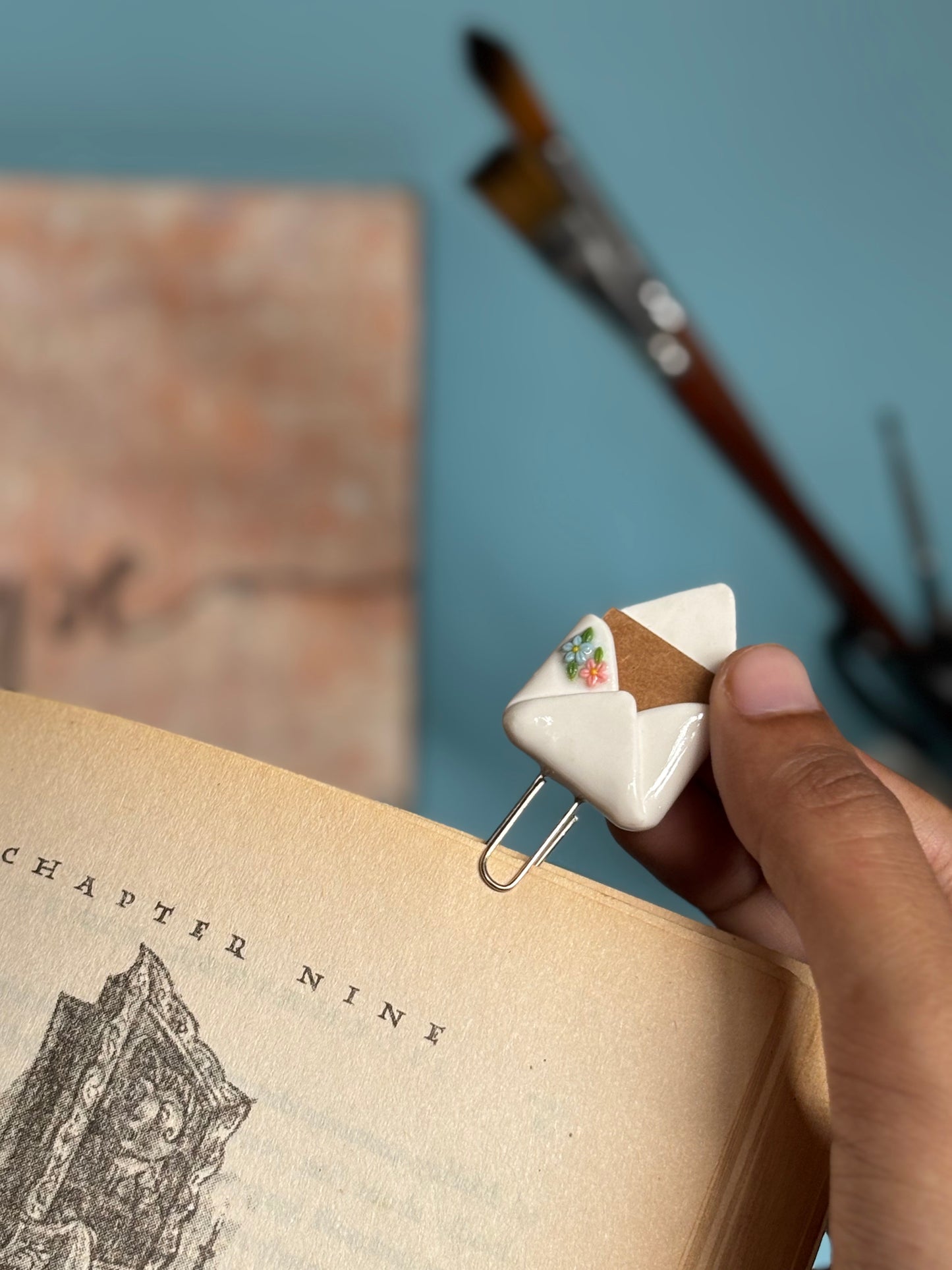Flopey envelope bookmark clipped to a book page