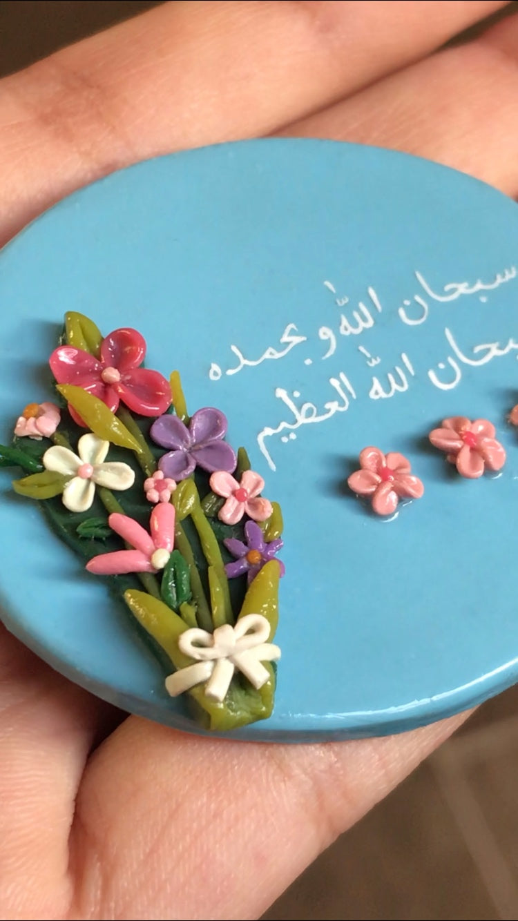 Close-up of handmade floral Islamic fridge magnet with SubhanAllahi wa bihamdihi Arabic calligraphy