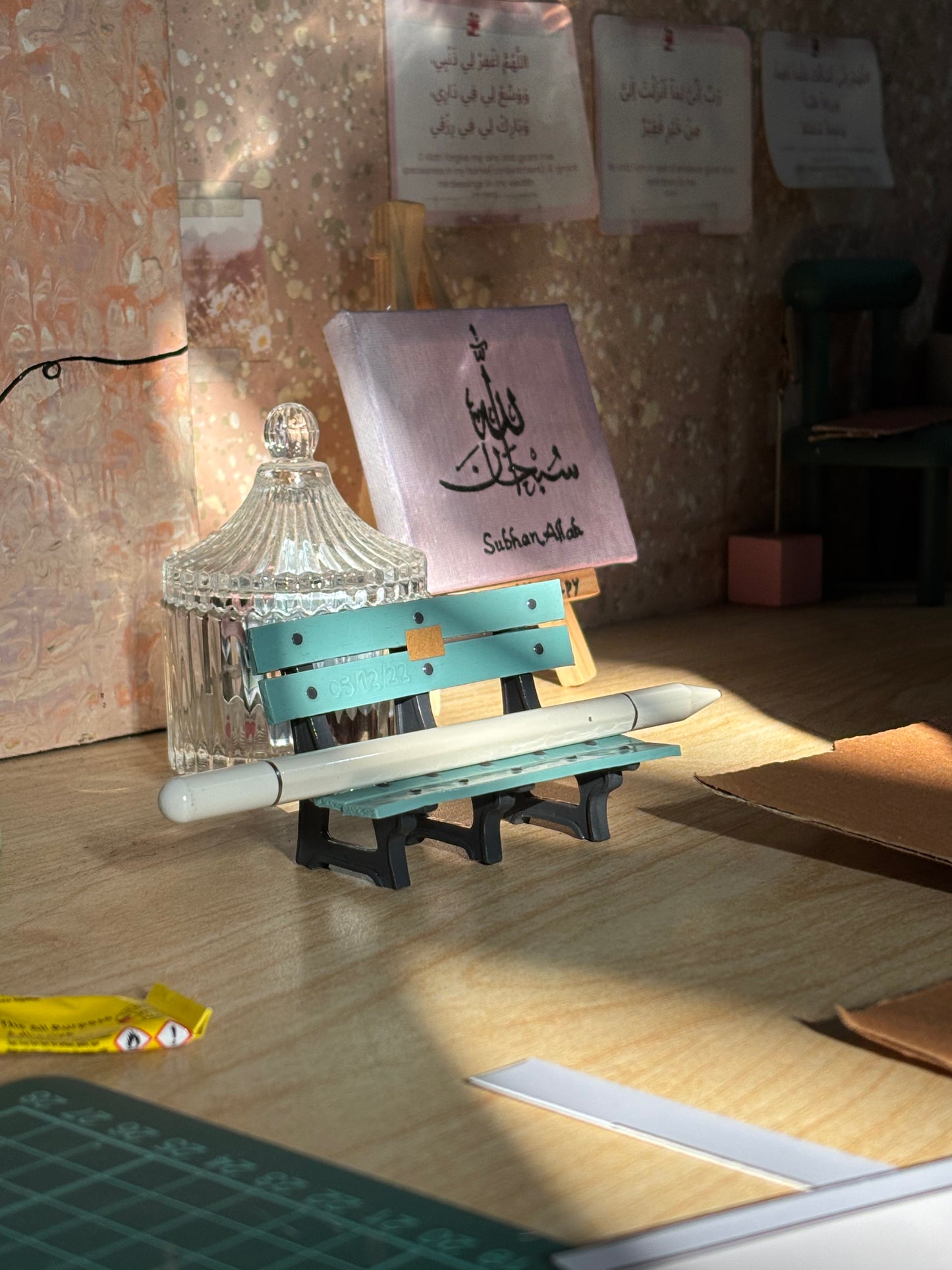 Turquoise miniature bench pen holder styled on a craft desk with a white pen